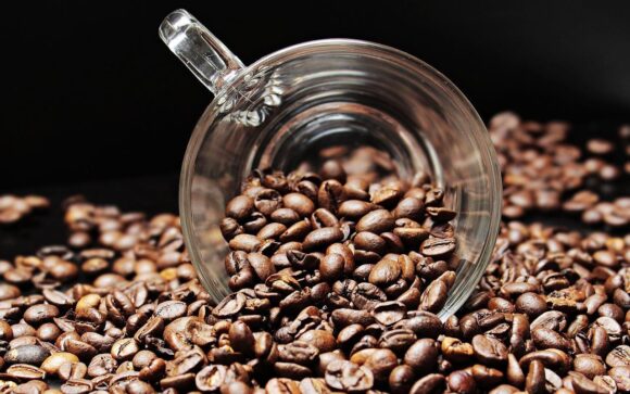 A picture of a cup of coffee beans that was spilled